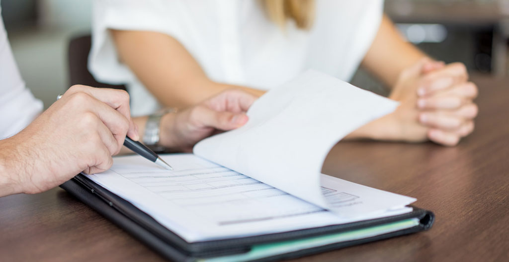 Cinq bulles de dialogue en papier avec points d'interrogation disposées en cercle autour d'une ampoule dorée allumée, symbolisant questions fréquentes et clarifications